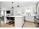 Open-concept kitchen featuring a breakfast bar, stainless appliances, and modern pendant lighting at 9157 Snow Hill Ct, Charlotte, NC 28269