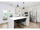 Bright kitchen with stainless steel appliances, center island with seating, and white cabinets at 9157 Snow Hill Ct, Charlotte, NC 28269