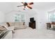 Bright living room with plush seating, a ceiling fan, and a large window that offers tons of natural light at 9157 Snow Hill Ct, Charlotte, NC 28269