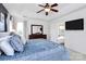 Comfortable main bedroom featuring a tray ceiling, ceiling fan and television at 9157 Snow Hill Ct, Charlotte, NC 28269