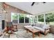 Cozy sunroom with a rocking chair, sofa, and large windows overlooking a beautiful garden at 9157 Snow Hill Ct, Charlotte, NC 28269