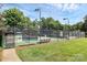 Outdoor tennis court surrounded by a black fence and green foliage at 9157 Snow Hill Ct, Charlotte, NC 28269