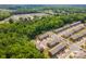 Aerial view of a residential community surrounded by lush green trees on a sunny day at 9203 Grand Valley Dr, Charlotte, NC 28213