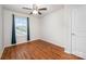 Bright bedroom featuring hardwood floors, ceiling fan, and a sunlit window with blue curtains at 9203 Grand Valley Dr, Charlotte, NC 28213