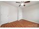 Bedroom featuring hardwood floors, a ceiling fan, and two white doors at 9203 Grand Valley Dr, Charlotte, NC 28213