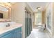 Vintage bathroom with blue vanity, arched doorway, and a glass block window at 1139 S Belvedere Ave, Gastonia, NC 28054