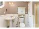 Charming bathroom with patterned wallpaper, pedestal sink, and built-in storage at 1139 S Belvedere Ave, Gastonia, NC 28054