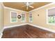 Comfortable bedroom with hardwood floors, multiple windows, and neutral decor at 1139 S Belvedere Ave, Gastonia, NC 28054
