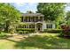Charming brick home with a manicured lawn, lush greenery, and a quaint front porch at 1139 S Belvedere Ave, Gastonia, NC 28054