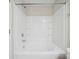 The bathtub features a shower head and pristine white tiled walls and shelving for bath products at 11530 Galashiels Dr, Huntersville, NC 28078