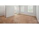 Sunlit bedroom with neutral carpet, white walls, and an ensuite bath through the open door at 11530 Galashiels Dr, Huntersville, NC 28078