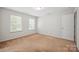 Well-lit bedroom with neutral carpet, two windows, white walls and trim at 11530 Galashiels Dr, Huntersville, NC 28078