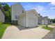 Exterior of garage with white door, siding, concrete driveway, and green lawn at 11530 Galashiels Dr, Huntersville, NC 28078