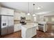 A well-lit kitchen with stainless steel appliances, a granite island and a view of the dining room at 11530 Galashiels Dr, Huntersville, NC 28078