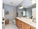 Bright bathroom with double sink vanity, patterned tile flooring, and a large framed mirror at 11647 Baystone Pl, Concord, NC 28025