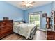 Bedroom with blue walls, ceiling fan, and a bright window with a backyard view at 11647 Baystone Pl, Concord, NC 28025