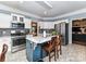 Spacious kitchen with stainless steel appliances, white cabinets, marble countertops, and breakfast bar at 11647 Baystone Pl, Concord, NC 28025