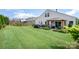 Expansive backyard with a covered patio, lush green grass, and a charming garden area at 1244 Tranquil Falls Ln, Matthews, NC 28104