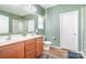 Bathroom with double sinks, wood cabinets, and walk-in shower at 1244 Tranquil Falls Ln, Matthews, NC 28104