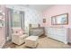 Charming Bedroom with a crib, dresser, area rug, chair, and floral decorations at 1244 Tranquil Falls Ln, Matthews, NC 28104