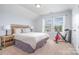 Bright bedroom with carpet, queen bed, lamps, windows and workout machine at 1244 Tranquil Falls Ln, Matthews, NC 28104