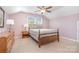 Bright bedroom with carpet, queen bed, wood furniture and window at 1244 Tranquil Falls Ln, Matthews, NC 28104