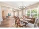 Elegant dining room featuring hardwood floors, a stylish chandelier, and ample natural light at 1244 Tranquil Falls Ln, Matthews, NC 28104
