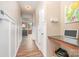 Hallway with wainscoting, hardwood floors, and a built-in desk at 1244 Tranquil Falls Ln, Matthews, NC 28104