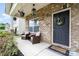 Inviting front porch with brick accents and cozy seating area, perfect for relaxing outdoors at 1244 Tranquil Falls Ln, Matthews, NC 28104