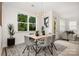 Bright dining room featuring a modern light fixture, a stylish rug and views of the surrounding greenery at 12744 Susanna Dr, Charlotte, NC 28214