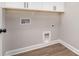 Laundry room with white cabinets, utility connections, and wood-look flooring at 12744 Susanna Dr, Charlotte, NC 28214