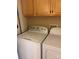 Convenient laundry room with full-sized white washer and dryer and overhead cabinets at 1326 5Th Ne St, Hickory, NC 28601