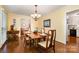 Cozy dining room featuring hardwood floors, a chandelier, and views into adjacent rooms at 14027 Springwater Dr, Matthews, NC 28105