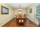 Bright and spacious dining room featuring hardwood floors, a chandelier, and large windows at 14027 Springwater Dr, Matthews, NC 28105