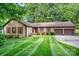 Charming single-story home with a well-manicured lawn, a two-car garage, and beautiful mature trees at 14027 Springwater Dr, Matthews, NC 28105
