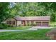 Charming single-story home with a well-manicured lawn, a two-car garage, and beautiful mature trees at 14027 Springwater Dr, Matthews, NC 28105