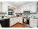Charming kitchen with white cabinets, granite countertops, stainless steel appliances, and hardwood floors at 14027 Springwater Dr, Matthews, NC 28105