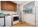 Functional laundry room with washer, dryer, storage cabinets, and a convenient clothing rack at 14027 Springwater Dr, Matthews, NC 28105