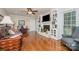 Inviting living room featuring built-in bookshelves, a fireplace, hardwood floors, and a ceiling fan at 14027 Springwater Dr, Matthews, NC 28105
