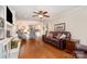 Comfortable living room featuring hardwood floors, a leather sofa, and an open layout to the kitchen at 14027 Springwater Dr, Matthews, NC 28105