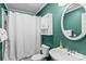Bathroom with green walls and white fixtures, including a round mirror and a shower with a curtain at 147 Bluewing Ln # 274, Mooresville, NC 28117