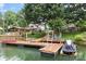 View of lake dock with boat dock, ladder, boat, and blue chairs perfect for lake-side living at 147 Bluewing Ln # 274, Mooresville, NC 28117