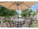 Outdoor patio with a mosaic-topped table, four chairs, an umbrella, and a waterfront view at 147 Bluewing Ln # 274, Mooresville, NC 28117