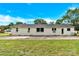 The back of the house with a large yard, simple landscaping, and off-white painted brick at 1501 E Church St, Cherryville, NC 28021