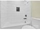 Bathroom featuring a white tiled tub/shower, a toilet, and neutral walls at 1501 E Church St, Cherryville, NC 28021