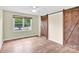 Neutral bedroom featuring hardwood floors, one window, a ceiling fan, and a sliding barn door at 1501 E Church St, Cherryville, NC 28021