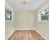 Room featuring two windows and wood-look flooring, illuminated by decorative chandelier at 1501 E Church St, Cherryville, NC 28021