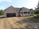 Charming single-Gathering home featuring a covered front porch and an attached two-car garage with gravel driveway at 153 Mason Tanner Ct, Rock Hill, SC 29730