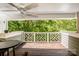 Spacious covered balcony with a wooden floor, white railing and a ceiling fan, with a lush green view at 19901 Henderson Rd # M, Cornelius, NC 28031