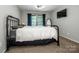 Bedroom features a metal bed frame, a window with blue curtains, and an oval mirror at 19901 Henderson Rd # M, Cornelius, NC 28031